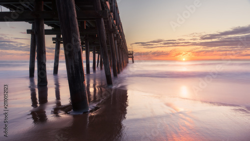 Sunrise view of the Sandbridge Fishing Pier in Virginia Beach, long exposure with smooth peaceful water