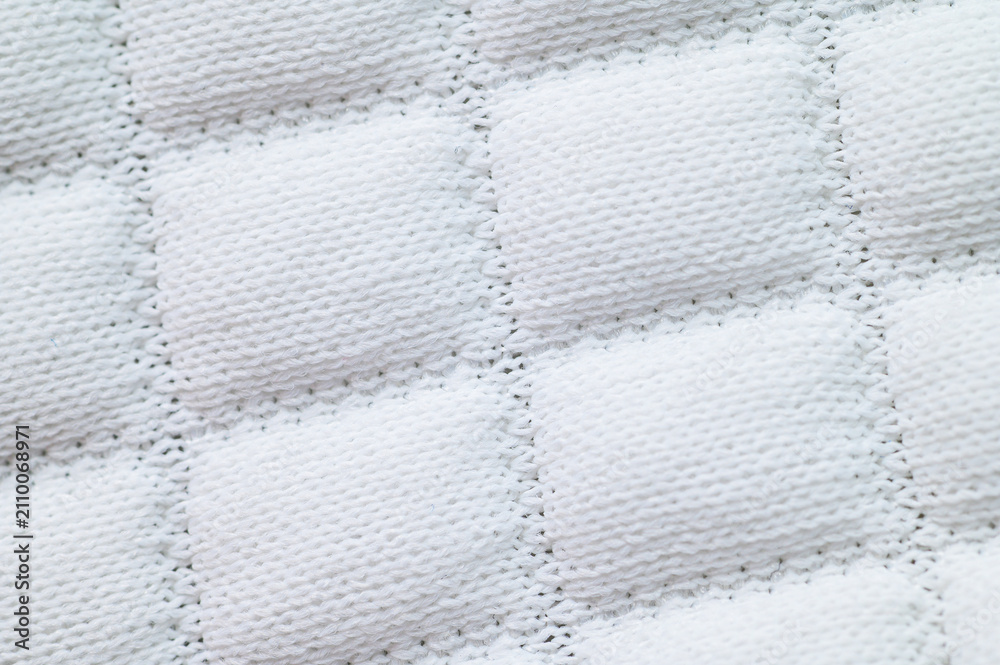 Obraz premium Close-up of white quilted fabric with square stitched pattern and soft texture
