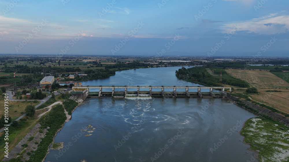 Fototapeta premium Isola Serafini Dam on Po river showing low water levels during a 2026 heatwave, reflecting climate change and drought conditions in Italys agricultural region