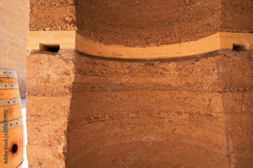 Obraz na plátně Close up detail of curved rammed earth wall with integrated wooden ring beam and