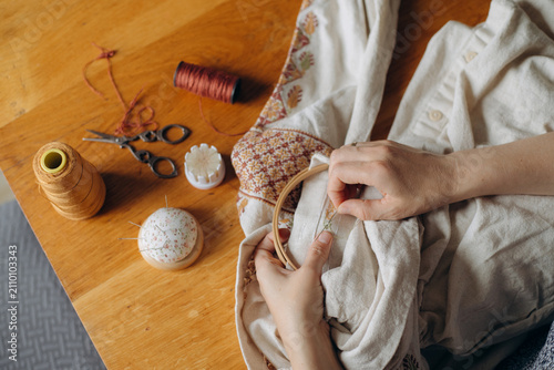 Woman embroidering traditional ukrainian cross stitch pattern
