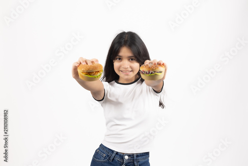 Happy girl holding two delicious glazed donuts looking through them
