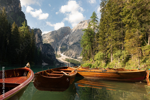 Foto Traditional rowing wooden boats on calm water of Lago di Braies lake in mountain landscape of Dolomites Alps Italy