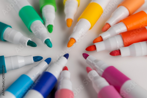 Top view of colorful felt tip pens arranged in a circle on white background
