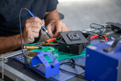 Foto Gros plan sur une réparation électronique en atelier avec outils professionnels