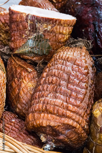 Fresh prepared smoked hams with spices on market stall