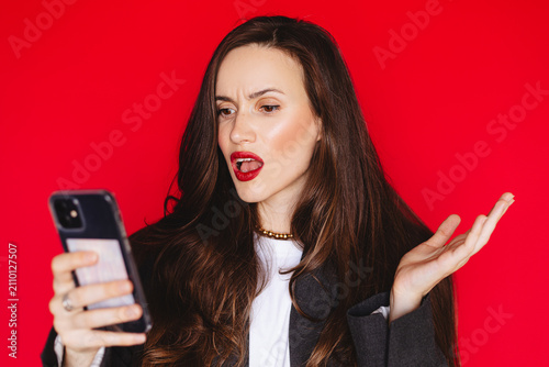 Fotografía Shocked confused young woman looking at smartphone screen with open mouth gestur