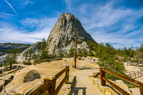 Принти на полотні Liberty Cap's granite dome rises above a scenic overlook with wooden railings and a lone pine tree in Yosemite National Park