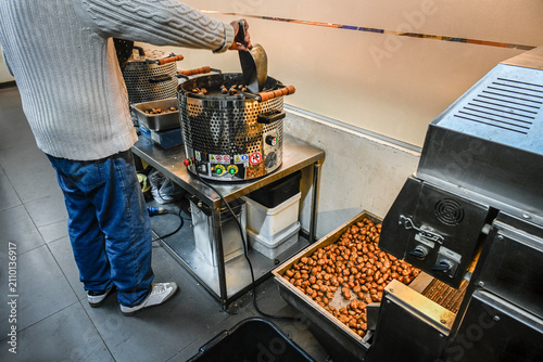 Фотография Stirring chestnuts in  a chestnut roaster in the city of Tayibe, Israel