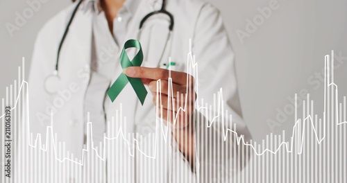 Doctor holding green ribbon ECG overlay starting, spiking and aligning near ribbon for awareness