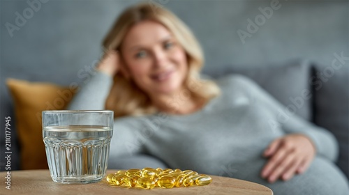 Pregnant woman taking omega 3 supplements for healthy pregnancy and fetal development