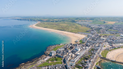 Aerial View of Portrush West Strand Beach and Harbor in Northern Ireland. Drone Shot of Scenic Coastal Bay and Turquoise Waters