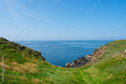 Canvas Print This scenic coastline view is Ramore Head in Portrush, Northern Ireland, featuring dramatic rock formations and the nearby Atlantic Ocean
