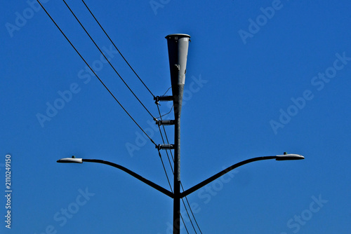 Consolidating street lights, electric lines and conical cellular antenna onto one pylon decrease city infrastructure costs 