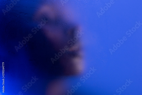 Black woman behind frosted glass with copyspace on background. 