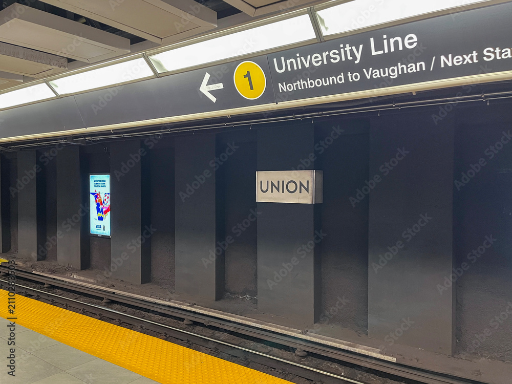 Obraz premium Empty Union station platform showing University Line sign and yellow tactile safety strip along track edge, Toronto July 2026