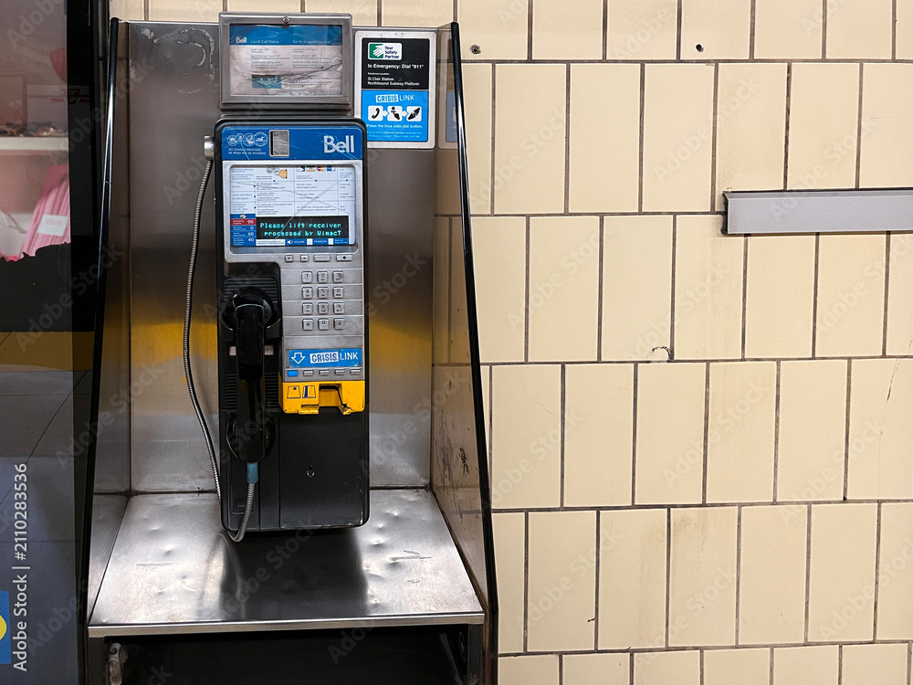 Obraz premium Bell payphone with crisis link information mounted on metal stand on transit subway station, Toronto Canada July 2026