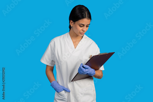 Healthcare professional reviewing patient information on clipboard