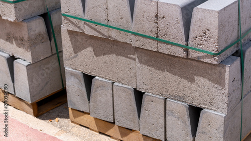 Принти на полотні Stacked Concrete Curbstones on Wooden Pallets at Construction Site