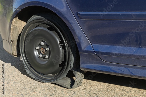 Bild auf Leinwand Shredded rubber tyre disintegrated from the wheel rim of a car after a temporary