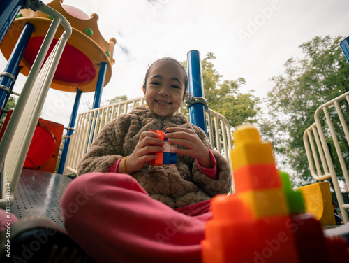 Child enjoys building with blocks on slide