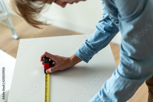 Foto Person measuring white surface precisely.