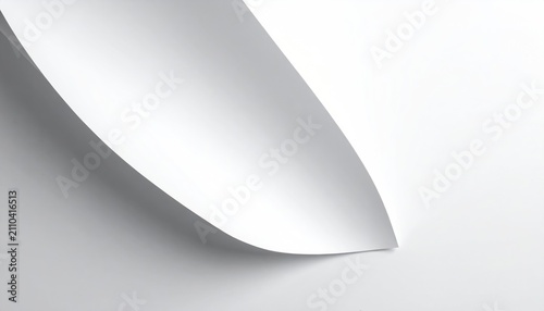 Close-up of curled paper corner, creating a shadow and revealing an otherwise concealed surface against a plain white backdrop