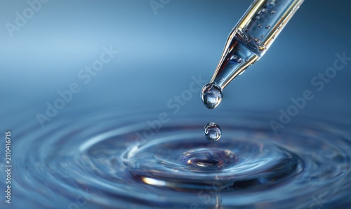 Close-up showcases a clear dropper dispensing liquid with droplets, creating ripples on a serene water surface in a blue environment