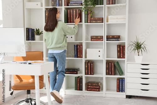 Young woman organizing book...