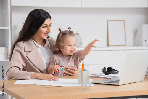 Young mother working remote...