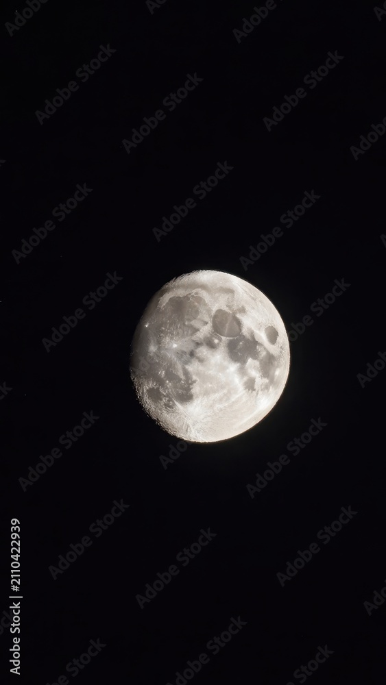 Naklejka premium Close up of the full moon glowing brightly in the dark night sky showing detailed lunar craters and surface texture against a pitch black background for astronomical concept