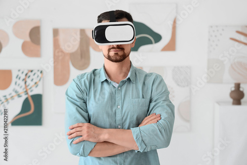 Young man with VR glasses in modern art gallery