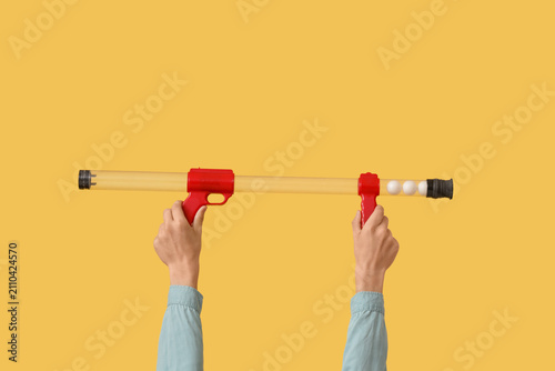 Photos Child with toy gun on yellow background