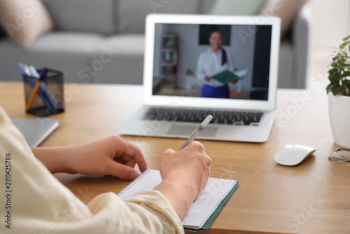 Male student studying online with teacher at home, closeup