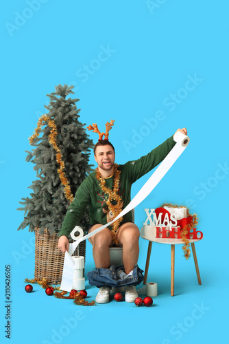 Young man sitting on toilet...