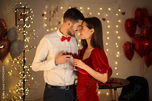 Young couple with glasses of wine at home on Valentines Day