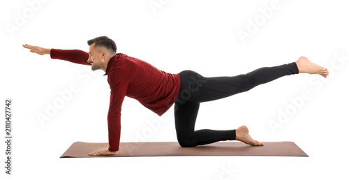 Handsome man doing yoga on ...