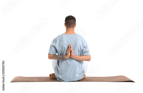 Young man doing yoga on mat...