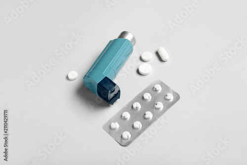 Asthma inhaler and pills on...