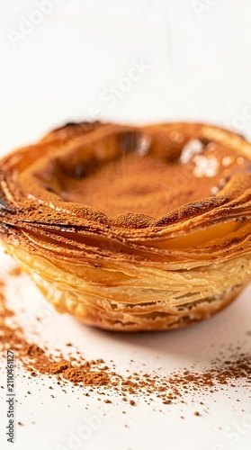 Portuguese egg tart with cinnamon powder on white background