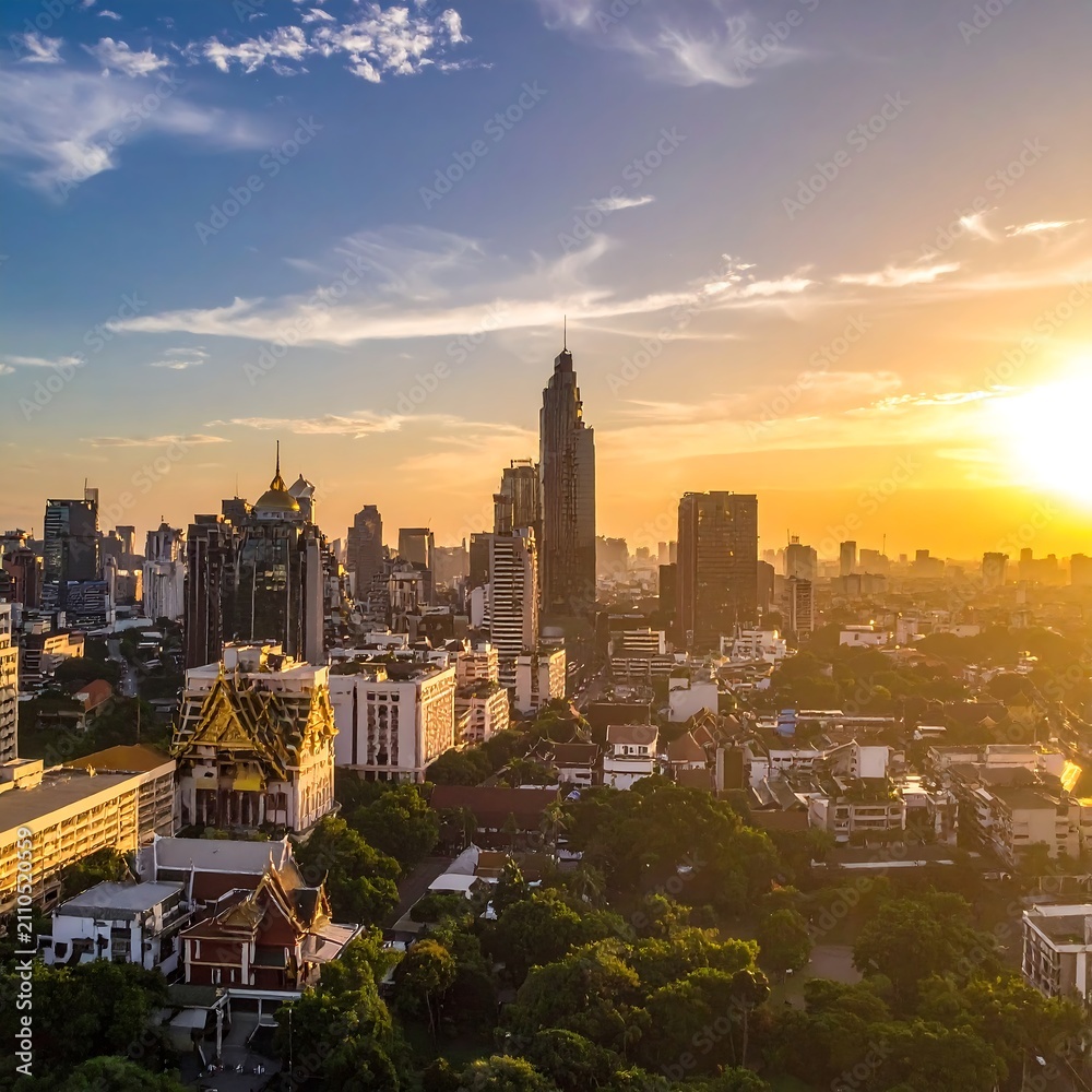 Fototapeta premium Aerial perspective showcases a densely populated urban setting illuminated by the warm light of a setting sun. Structures tower