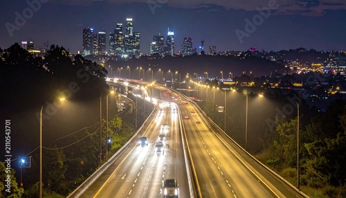 Highway illuminated at night leading to a distant city skyline, with blurred car lights and streetlamps