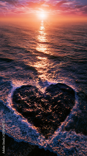 Heart shaped ocean sunset seascape aerial view water wave foam horizon pink sky romantic sea