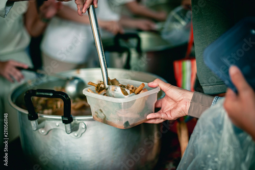 Volunteers donating food to people in a society in need of food , Volunteers Share Food to the Poor