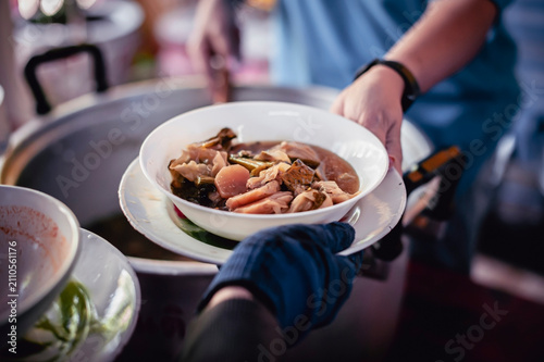 Volunteers donating food to people in a society in need of food , Volunteers Share Food to the Poor