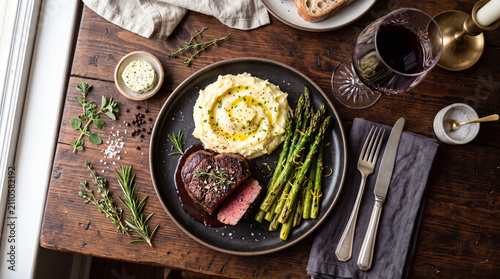 Romantic candlelight dinner for two with beef steak and red wine in a cozy luxury restaurant.