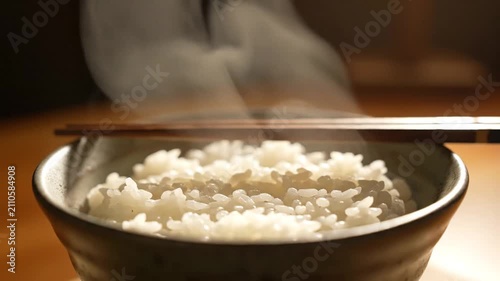 Steaming Bowl of White Rice Served with Chopsticks and Soft Ambient Lighting