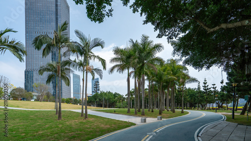 Quadro su tela Urban Park with Palm Trees and Modern Buildings