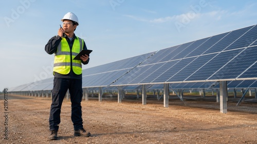 Engineer assessing solar panel setup with clipboard in the renewable energy sector