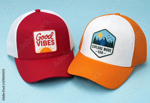 Two stylish caps rest side by side on a soft blue surface
